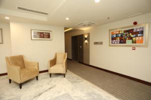 伊斯兰堡IFQ Hotel & Resort的一间设有两把椅子的等候室和墙上的一幅画