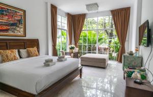 Ban Nong SrahUtapao sattahip rayong resort的一间卧室设有一张大床和一个大窗户