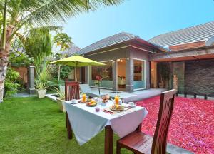 塞米亚克布阿巴厘岛别墅酒店的后院里一张桌子,上面有食物和雨伞