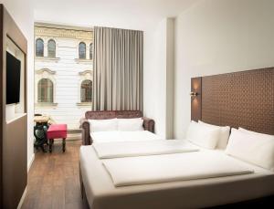 莱比锡elaya hotel leipzig city center的酒店客房设有两张床和窗户。