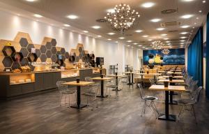 莱比锡elaya hotel leipzig city center的一间带桌椅和柜台的餐厅