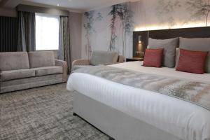普雷斯顿巴顿农庄酒店的酒店客房设有一张大床和一张沙发。
