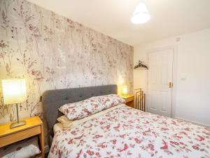 阿尔弗斯顿Monument Way的一间卧室配有一张带花卉壁纸的床