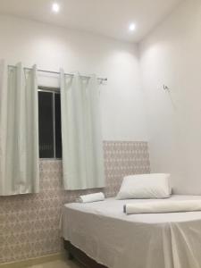 巴雷里尼亚斯Rosana House Bem estar em Barreirinhas Ideal para 5 pessoas的一间卧室设有两张床和窗户。