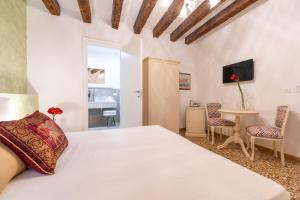 威尼斯Residenza San Silvestro的卧室配有一张床和一张桌子及椅子