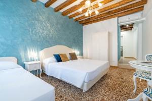 威尼斯Residenza San Silvestro的一间卧室设有两张床和蓝色的墙壁