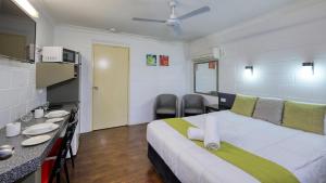 库纳巴拉布兰Azalea Motel的一间卧室配有一张大床和一张桌子及椅子