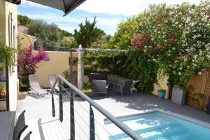 蒙彼利埃Jolie Villa, Piscine, 10min centre ville, WIFI的一个带游泳池和鲜花的阳台
