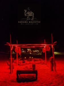 梅尔祖卡Sahara Majestic Luxury Camp的夜晚沙子里有红灯的舞台