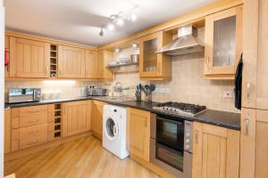 布里斯托Blaisedell House by Cliftonvalley Apartments的厨房配有木制橱柜、洗衣机和烘干机