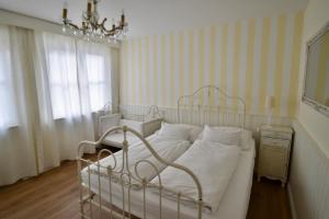 杜塞尔多夫哈姆酒店的卧室配有白色的床和吊灯。