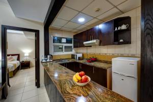 沙迦奥哈亚特公寓酒店的厨房在柜台上放一碗水果