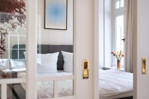 费尔登Altstadt Apartments Verden的卧室配有白色的床和窗户。