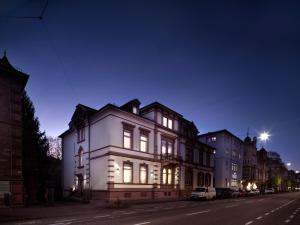 海德堡Boarding World Heidelberg的夜幕降临的城市街道上的白色房子