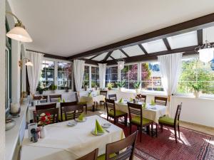 布里克森谷地霍普夫加尔滕玛格雷特乡村酒店的餐厅设有白色的桌椅和窗户。