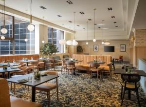 伯明翰Leonardo Royal Hotel Birmingham的餐厅设有桌椅和窗户。