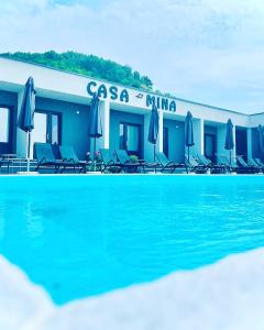 DiviciCasa Mina Divici的游泳池旁的酒店拥有椅子和遮阳伞