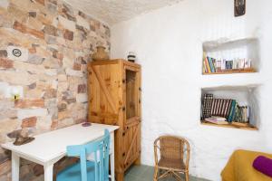 Lomo de AricoCasa Cueva Gaspara的一间设有白色桌子和木制橱柜的客房