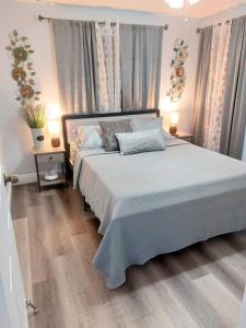 坦帕Torres Tiny Home Midtown WestTampa RJS的卧室配有一张带两张桌子的大型白色床