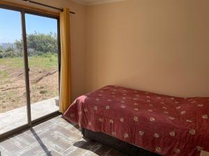 通戈伊Casa de campo, con hermosa vista al mar的一间卧室设有一张床和一个大窗户