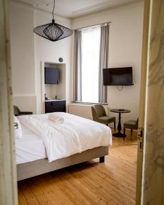 根特Heirloom Hotels - The Mansion的一间卧室配有一张床、一张书桌和一台电视