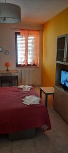 波坦察Le Gemme del Centro Storico的一间卧室配有红色的床和电视