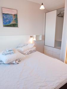 福堡Strand Huset的白色客房的两张床,配有镜子