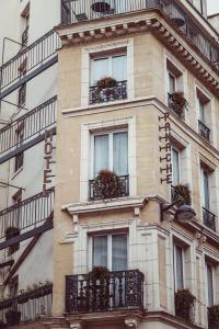 巴黎帕纳奇酒店的一座高大的建筑,设有阳台,种有植物