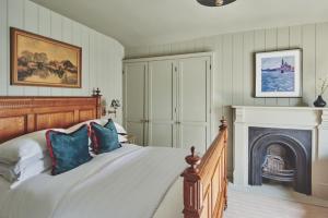 考斯Harold House的一间卧室配有一张床和一个壁炉