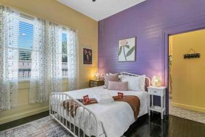 坦帕FRIENDS AIRBNB Themed 2bed 2bath walkable to all of Ybor的紫色卧室配有白色的床和窗户