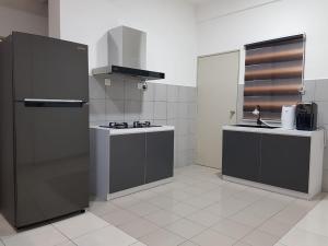山打根Best memories Apartment in Sandakan的厨房配有黑色冰箱和水槽
