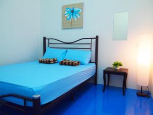 马六甲The Cardamom Hostel的蓝色卧室,配有蓝色床单