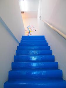 马六甲The Cardamom Hostel的一间房间带蓝色楼梯的楼梯间