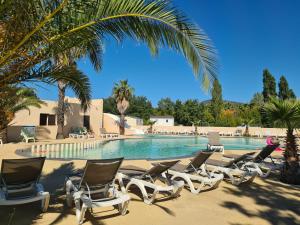 格里莫Camping Domaine Du Golfe De Saint Tropez的一组躺椅,位于游泳池旁