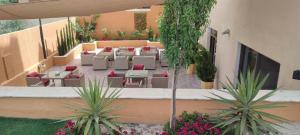 马达巴Black Iris Hotel II的户外庭院设有桌椅和植物