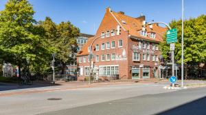 埃姆登库尔福厄斯特斯塔特长酒店的一条空的街道,在一座大型砖砌建筑前
