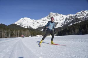 阿德蒙特Haus Rosina的一位在雪中滑雪的人,背景是山