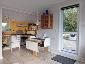福堡Strand Huset的厨房配有桌椅和窗户。