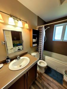 马塔讷Maison St-Raymond Duplex的一间带水槽、卫生间和镜子的浴室