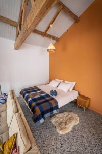 HemDe Kaasmakerij - Ruim vakantiehuisje op Huize Blokland的一间卧室配有一张床和一张沙发
