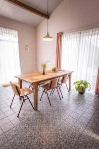 HemDe Kaasmakerij - Ruim vakantiehuisje op Huize Blokland的带窗户的客房配有一张木桌和椅子