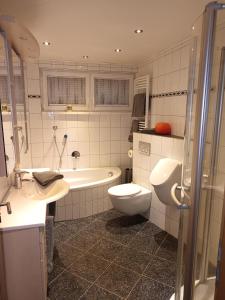 HildersHaus Luise Weber的浴室配有卫生间、浴缸和水槽。