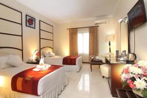 玛琅Aliante Malang的酒店客房设有两张床和电视。