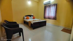 蒂鲁瓦纳马莱Aadhya guest house的一间卧室配有床、椅子和窗户