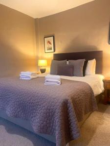 Froggatt契克斯旅馆的一间卧室配有一张大床和毛巾