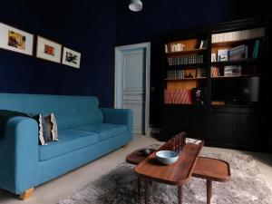 Saint-Martin-lez-TatinghemMille et une feuilles的客厅配有蓝色的沙发和桌子