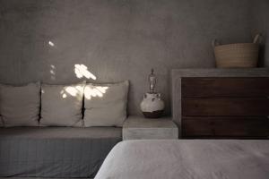 托多斯桑托斯Desierto Azul的一间卧室配有一张带白色床单的床和梳妆台。