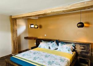 MakindyeThe Forest Resort - Lweza的一间卧室配有一张带木制床头板的床