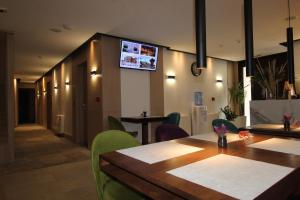 萨拉热窝Hotel Boss的一间带桌椅的餐厅以及墙上的电视