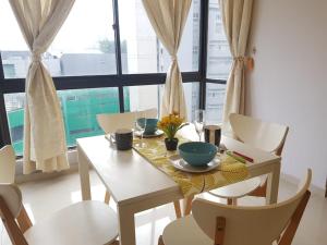 吉隆坡Bukit Bintang Fahrenheit88 Apartment by Sarah's Lodge的餐桌、桌椅和窗户